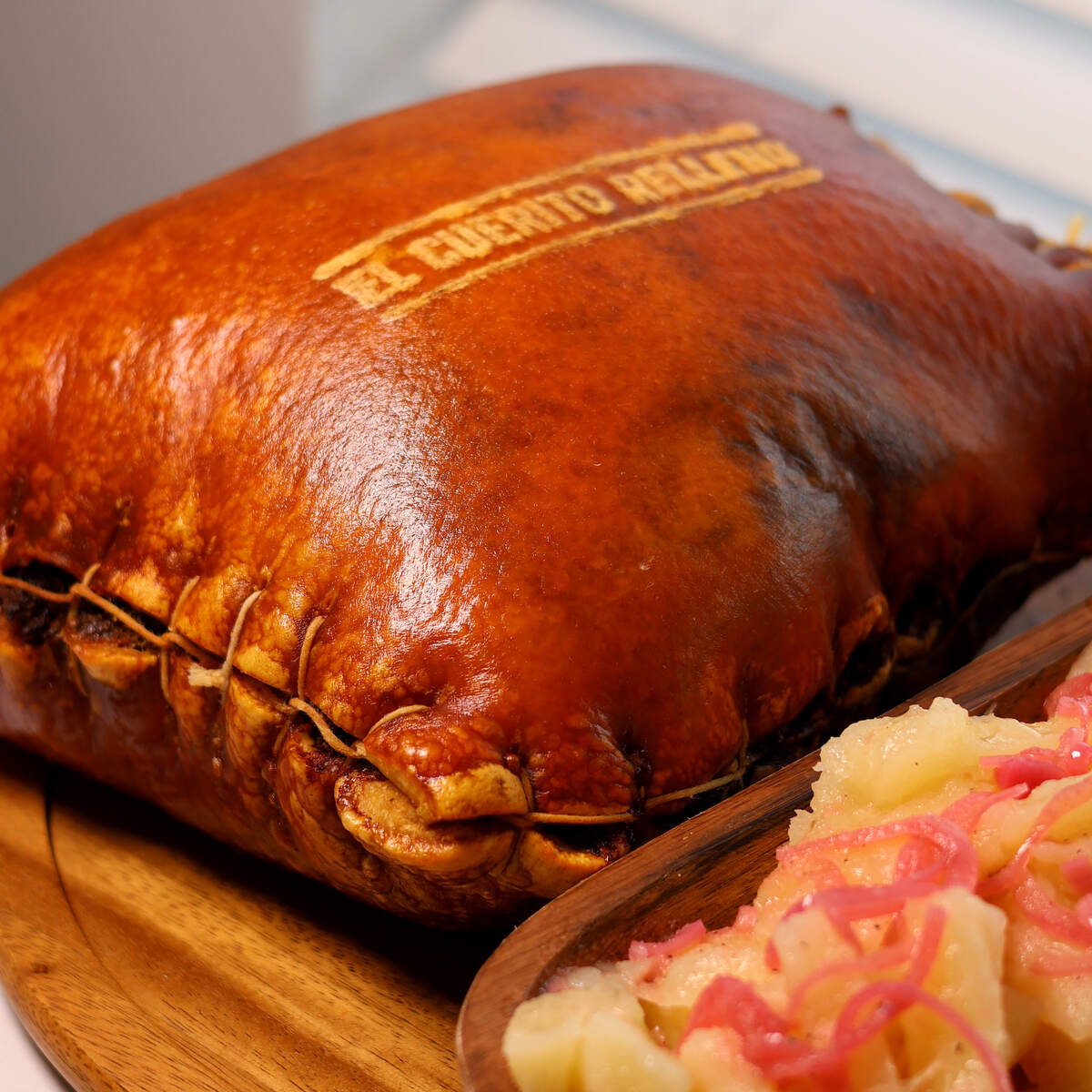 Cuero relleno recién asado con la marca El Cuerito Relleno, servido con yuca con mojo